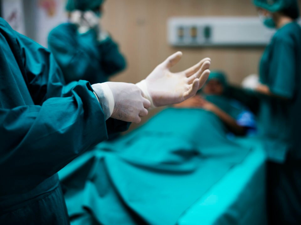 fotografia de médicos na sala de cirurgia, se preparando para realizar o procedimento artrodese.