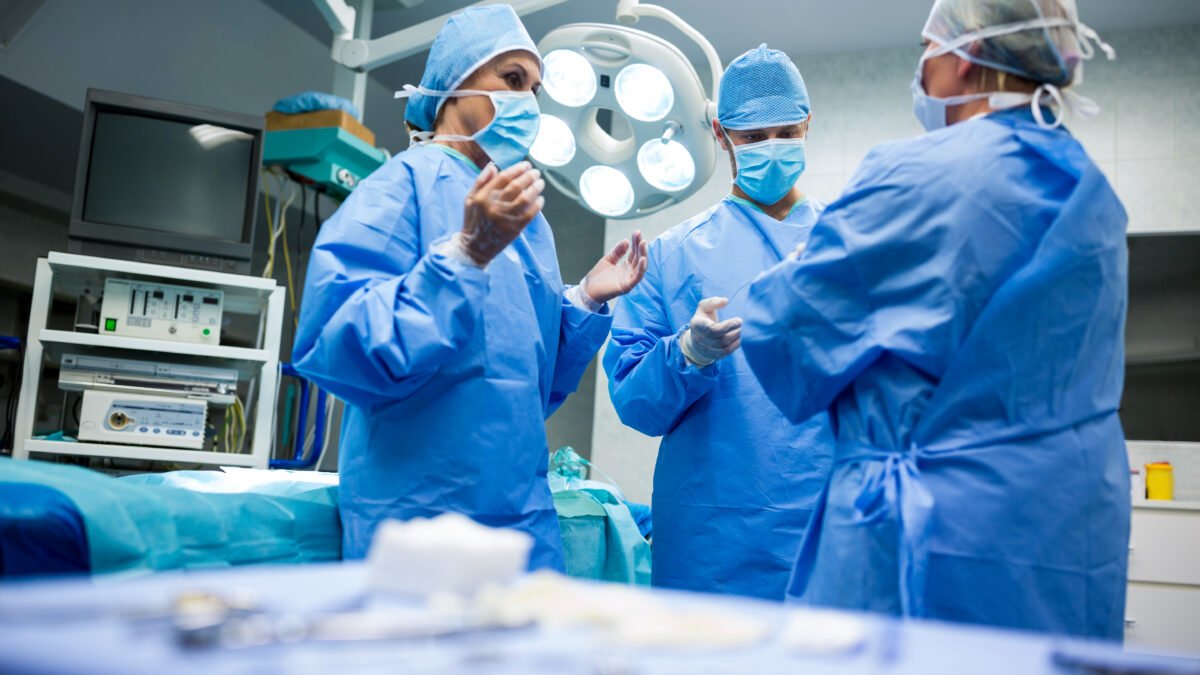 fotografia de equipe médica se preparando para uma cirurgia de dor na coluna. Eles já estão na sala de cirurgia.