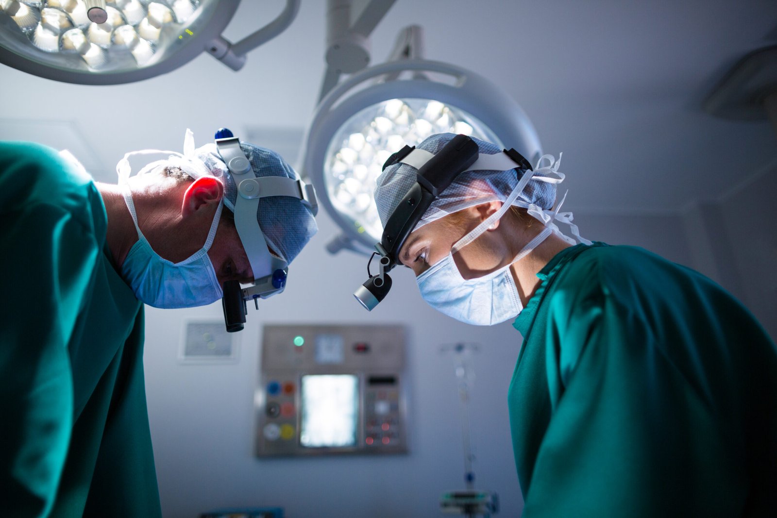 Fotografia de dois neurologistas realizando uma cirurgia de escoliose.