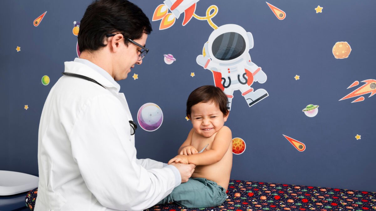 Fotografia de um médico examinando um bebê que pode estar com hidrocefalia.