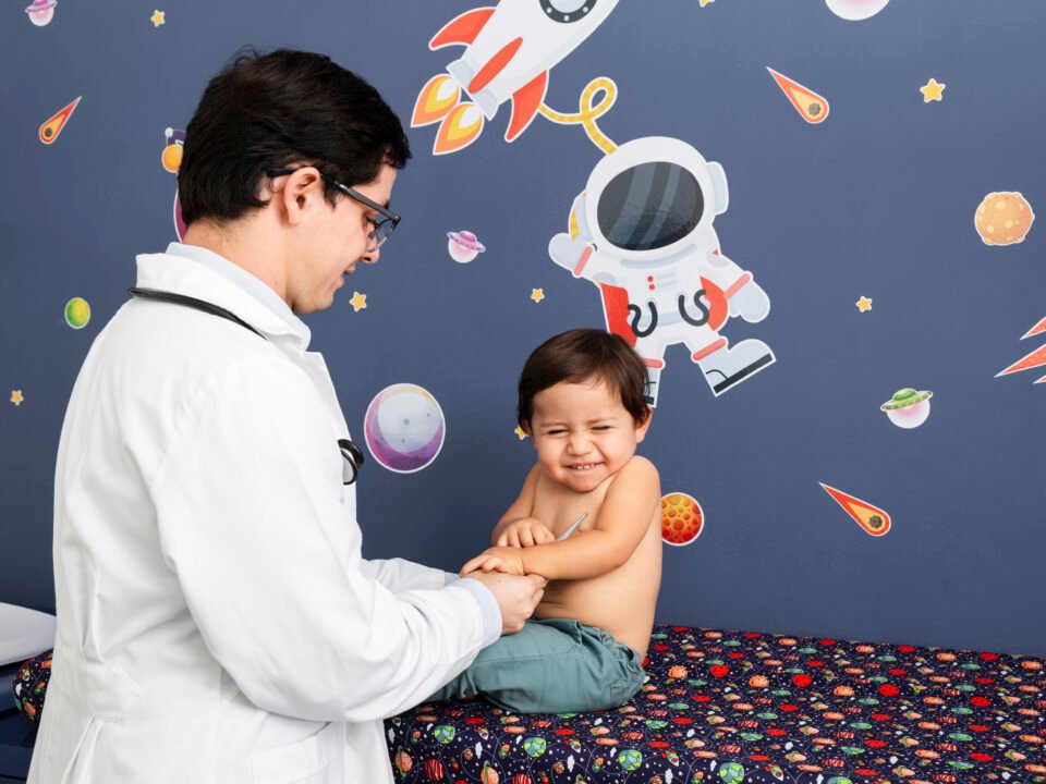 Fotografia de um médico examinando um bebê que pode estar com hidrocefalia.