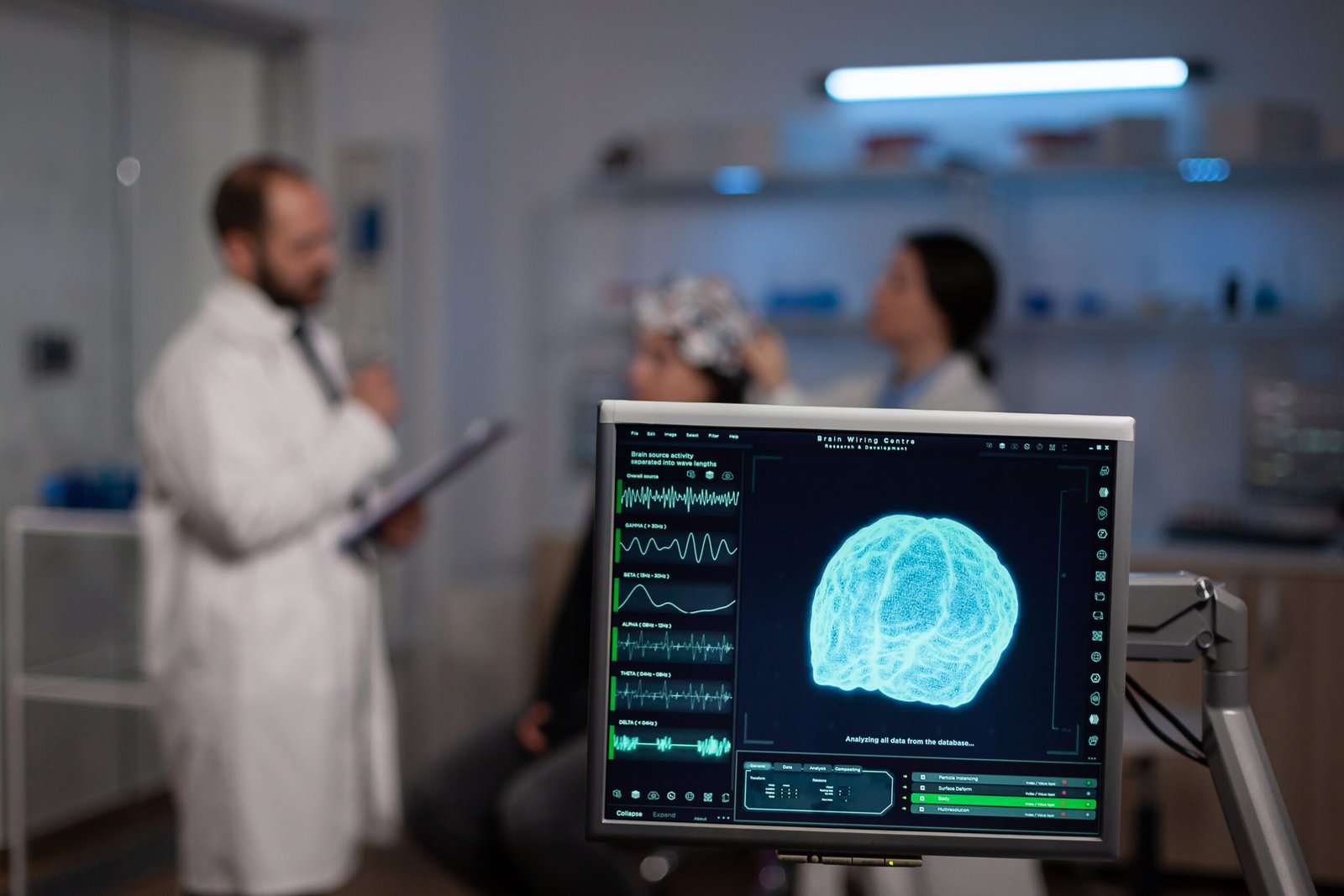 Fotografia de dois médicos realizando alguns exames cerebrais na paciente sentada na cadeira. Há uma tela mostrando imagens cerebrais do paciente.