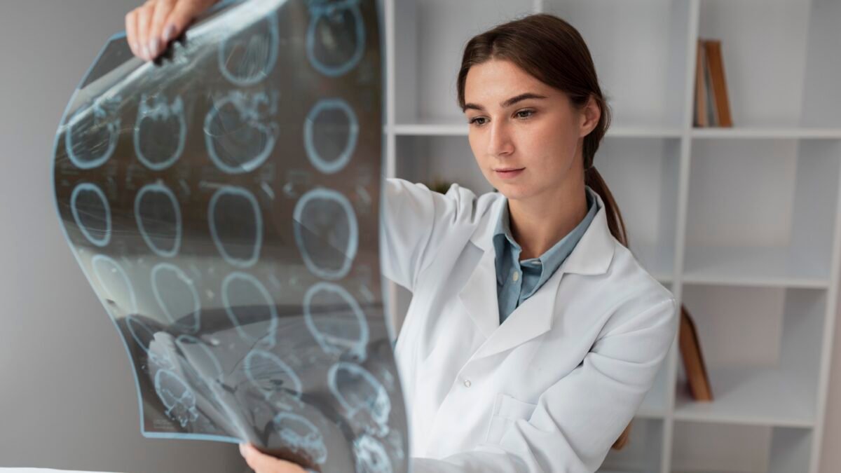 Fotografia de médica neurologista olhando um exame de imagem do crânio do paciente.